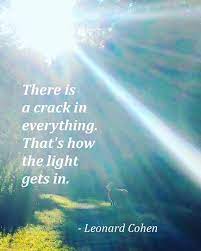 An image featuring sunlight streaming through trees with the quote, 'There is a crack in everything. That's how the light gets in.' - Leonard Cohen